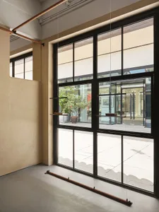 Industrial-style office space featuring metal frame windows and minimalist design elements.