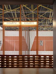 Industrial-style tennis court with brick walls and a net.