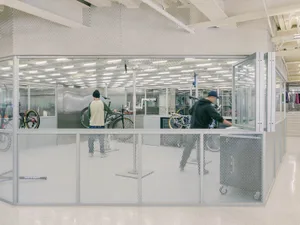Industrial-style workspace with glass dividers and metal elements.