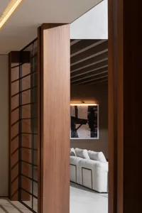 A minimalist living room featuring a white sofa, wooden panels, and a modern artwork on the wall.