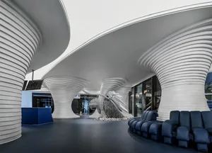 A modern hotel lobby featuring curved concrete columns and a futuristic design.