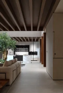 Minimalist kitchen with white countertops, dark cabinets, and industrial lighting.