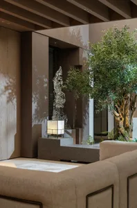 A modern living room featuring concrete walls and a potted plant.