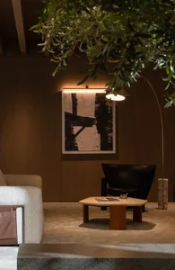 Modern living room interior featuring a sleek leather chair, a wooden coffee table, and minimalist artwork on the wall.
