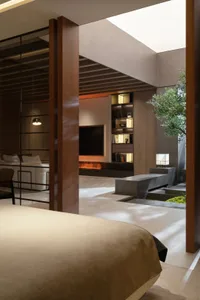 An interior design featuring a modern minimalist living room with concrete elements, large windows, and a sleek fireplace.
