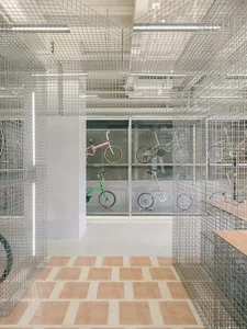 A modern interior space featuring metal grid storage for bikes.