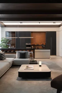 Modern living room with minimalist design, wooden accents, and a glass coffee table.