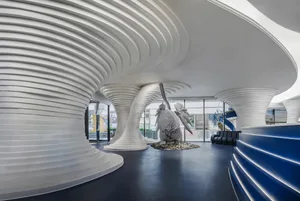 A sleek, modern corporate reception area featuring white and blue concrete design elements.