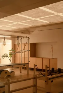 A minimalist workout room with wooden floors, barre, and fitness equipment.