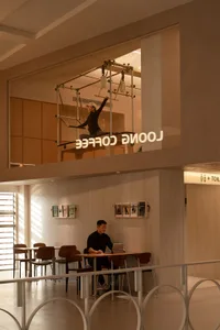 A modern coffee shop featuring industrial design elements, with a wooden counter and metal fixtures.