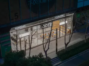 A modern coffee shop with large glass windows, tables, and chairs.