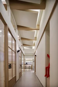 Modern interior corridor with wooden ceiling and glass doors.