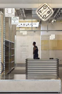 A spacious modern cycling shop featuring metal shelves, glass walls, and concrete flooring.