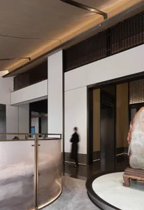 A modern hotel lobby features glass detailing, contemporary lighting, and minimalist design elements.