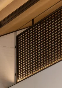 Modern interior with a metal grid wall and wooden ceiling beams.