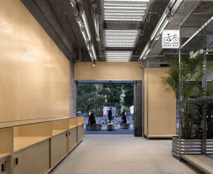 A modern retail storefront featuring wooden panels and concrete structural elements.