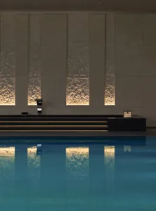 A modern swimming pool illuminated by backlit walls, providing a luxurious and serene atmosphere.