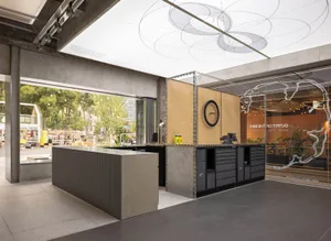 Modern interior design featuring a workshop area with concrete and steel materials.