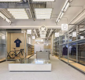 A clothing retail space featuring industrial-style metal shelves and concrete floors.