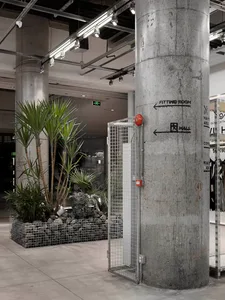 Industrial storefront featuring concrete pillars and greenery in a modern design