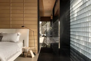 A modern bedroom featuring wooden walls and a glass wall