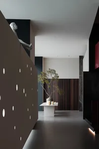 A modern interior featuring a wooden wall, sculpture, and plant.