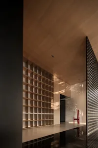 A modern interior space featuring wooden shelves and a red chair.