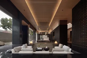 A minimalist lounge area with concrete flooring and minimalist furniture.