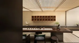 Modern tea room featuring wooden shelves, a tea table, and chairs.