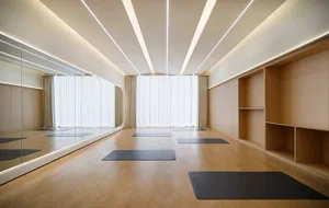 現代瑜伽工作室，採用木質地板、玻璃牆面與鏡面設計。