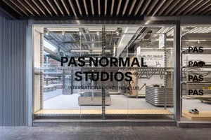 A modern, industrial retail storefront featuring a glass facade and minimalist design.