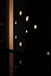 Minimalist interior design featuring illuminated circular lights reflected in a polished surface.