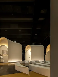 Modern exhibition space with white, curved, minimalist architectural panels