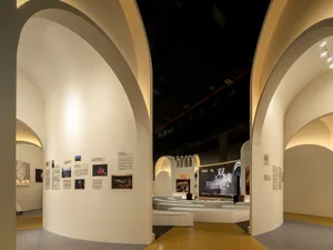 An exhibition space with modern design featuring white walls and circular columns.
