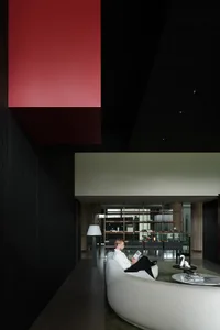 A modern living room featuring a minimalist design with a concrete finish on the walls and floor.