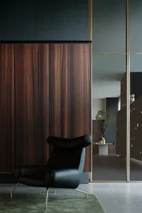 A modern minimalist living space featuring dark wood and metal furniture.