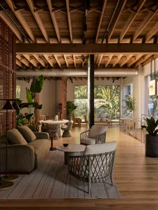 A spacious, industrial-style coffee shop with a wooden ceiling, exposed beams, and a cozy seating area.