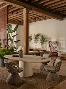 An industrial living room with wood flooring, a wooden beam, and a concrete table.