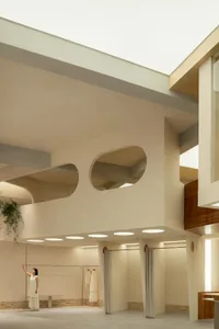 A modern minimalist interior space with concrete walls, an open ceiling, and minimalist fixtures.