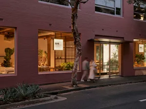 極簡店面，磚牆搭配大片玻璃窗與綠色植栽