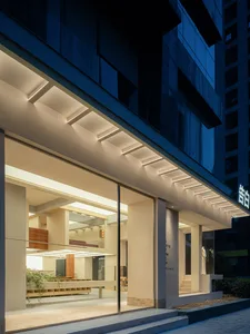 Modern retail storefront with large glass windows and concrete elements.