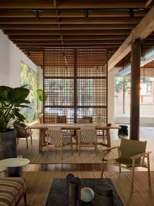 Indoor living room with wooden furniture, plants, and a large window