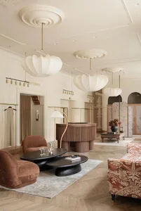Modern lobby featuring wooden tables, fabric armchairs, and leather accents