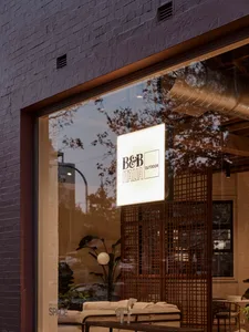 A modern storefront with a glass facade featuring botanical elements.