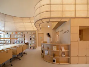 A modern library interior with wooden shelves and fabric lighting