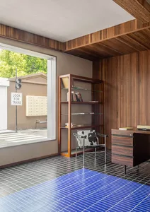 A modern office space featuring wooden elements and a blue tiled floor.