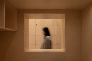 A minimalist interior space with wooden panels and a square light fixture.