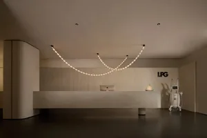 A minimalist reception desk with a concrete finish, featuring a sleek design and modern lighting.