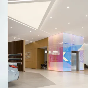 A minimalist showroom featuring colorful glass cladding on the walls.