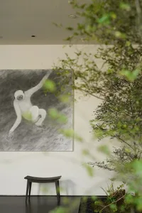 A black and white drawing of a monkey displayed on a wall.